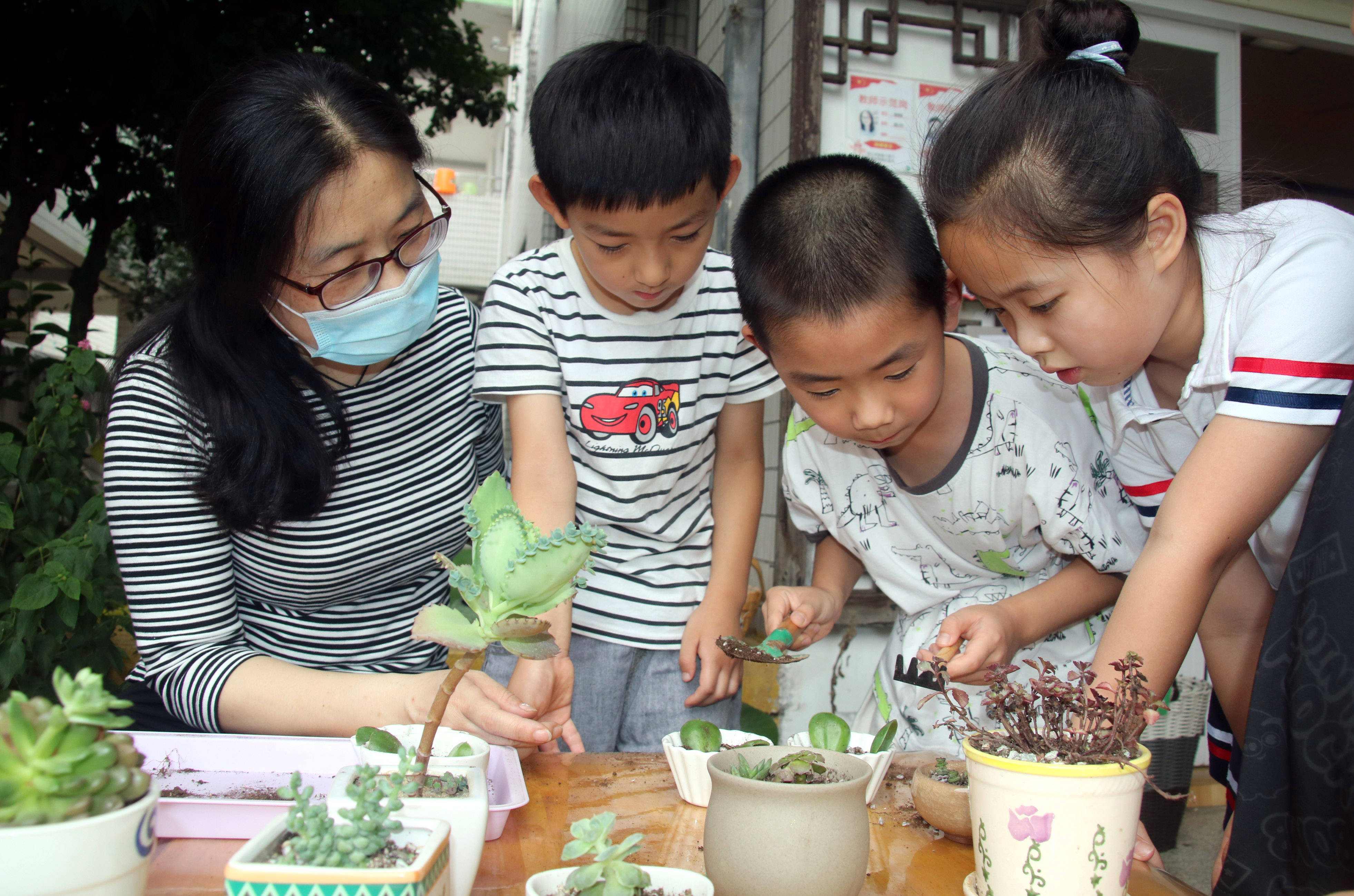 2020年7月14日,江苏省苏州市虎丘中心幼儿园孩子在老师指导下播种