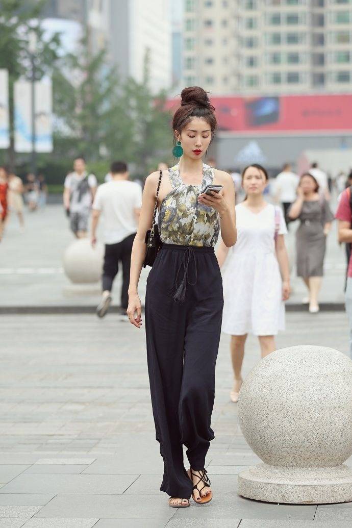 街拍:阔腿裤更加的显瘦,搭配一件印花的小吊带,小美女真是美极了