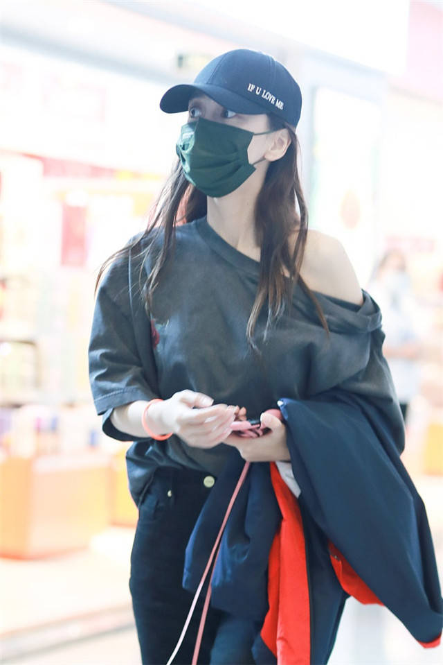 Baby现身机场穿宽松T恤秀香肩,长靴美腿抢镜