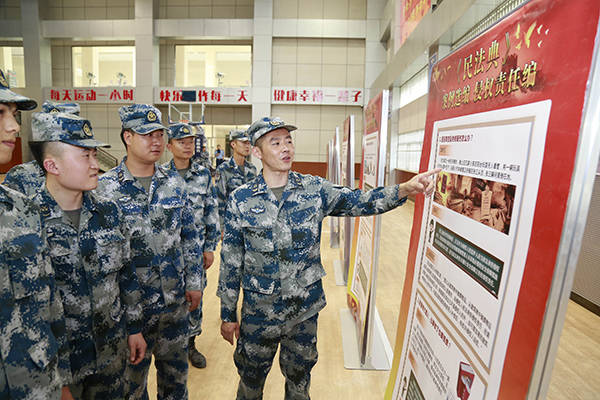 图为空军某基地官兵正在参观"与民法典同行"挂图展览.