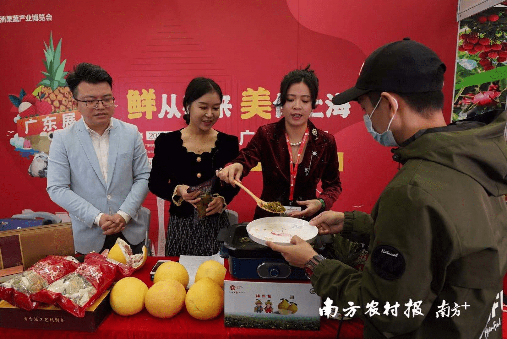 德庆县双华食品厂董事长梁碧华(右一)现场烹煮德庆酸豆角.