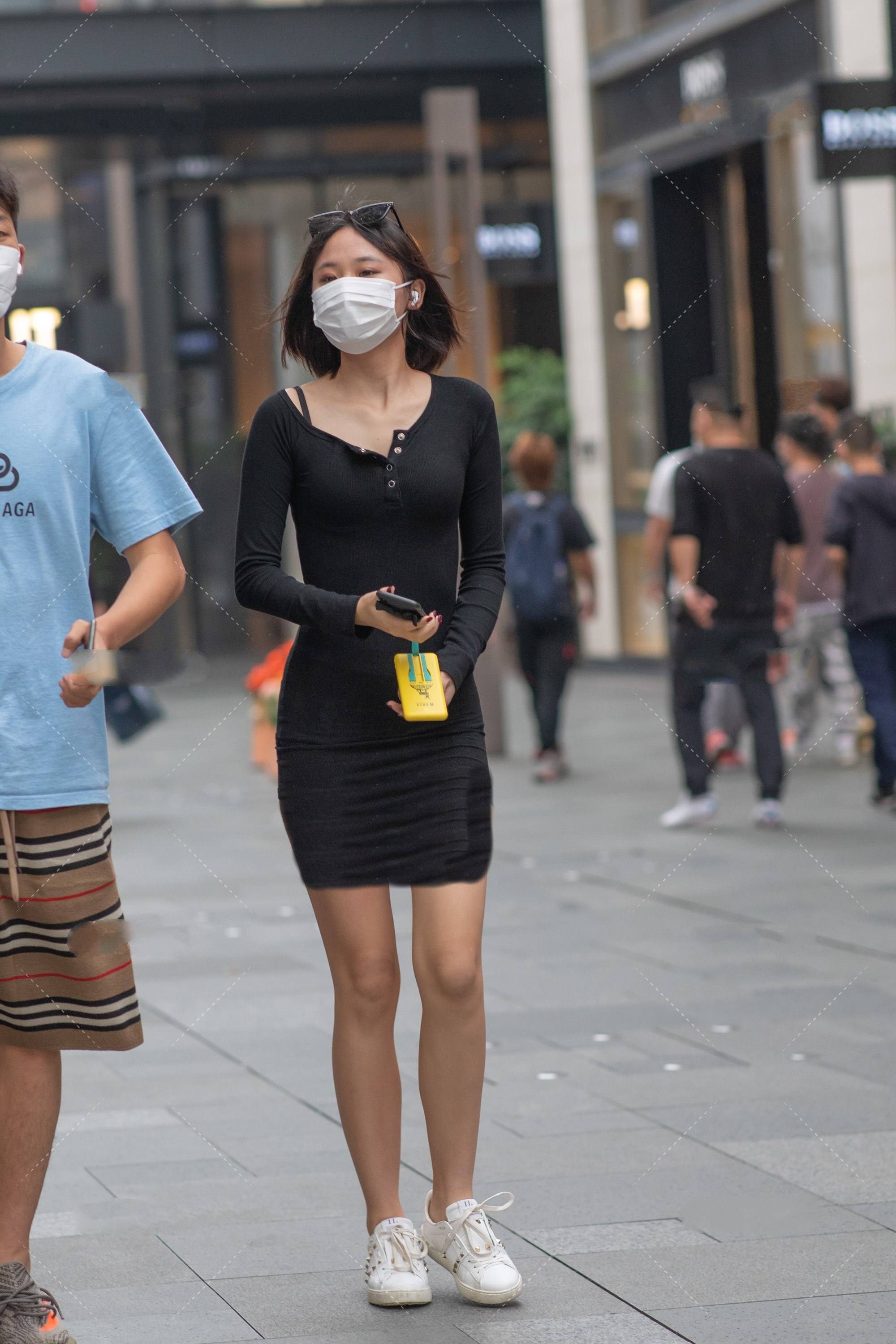 街拍美女:黑色紧身短裙搭配必备小白鞋,大长腿一览无