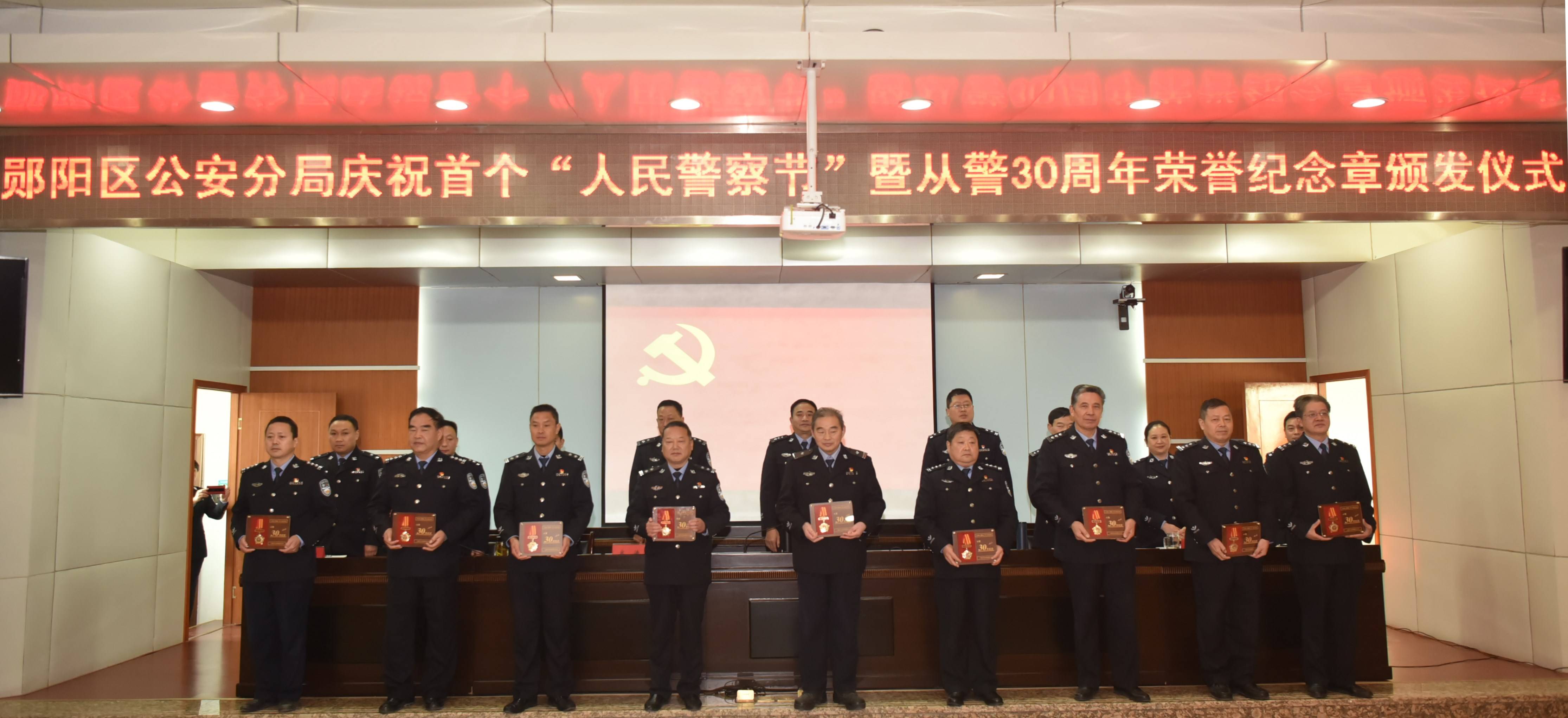 图为十堰市公安局郧阳区分局党委为从警满30周年民警颁发纪念章 (张君