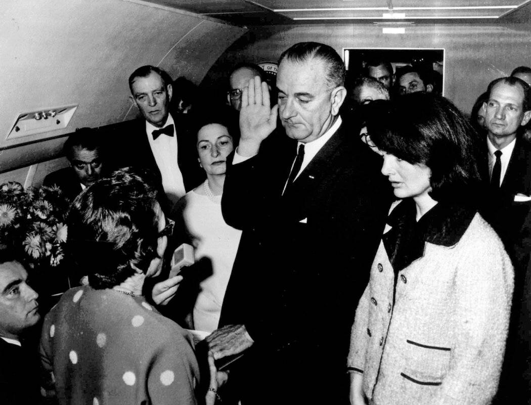 (图:林登·b·约翰逊在总统专机上宣誓就任总统,右侧是肯尼迪的遗孀