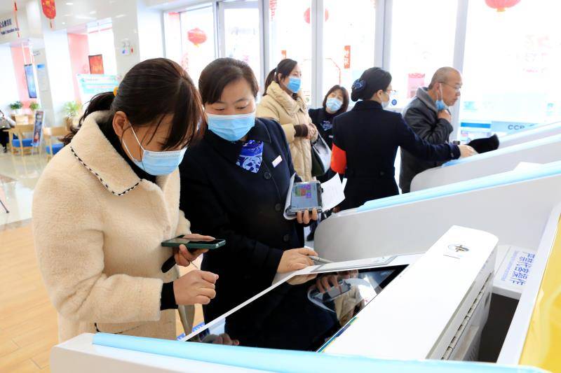 图为工作人员协助客户使用自助设备 返回搜 责任编辑