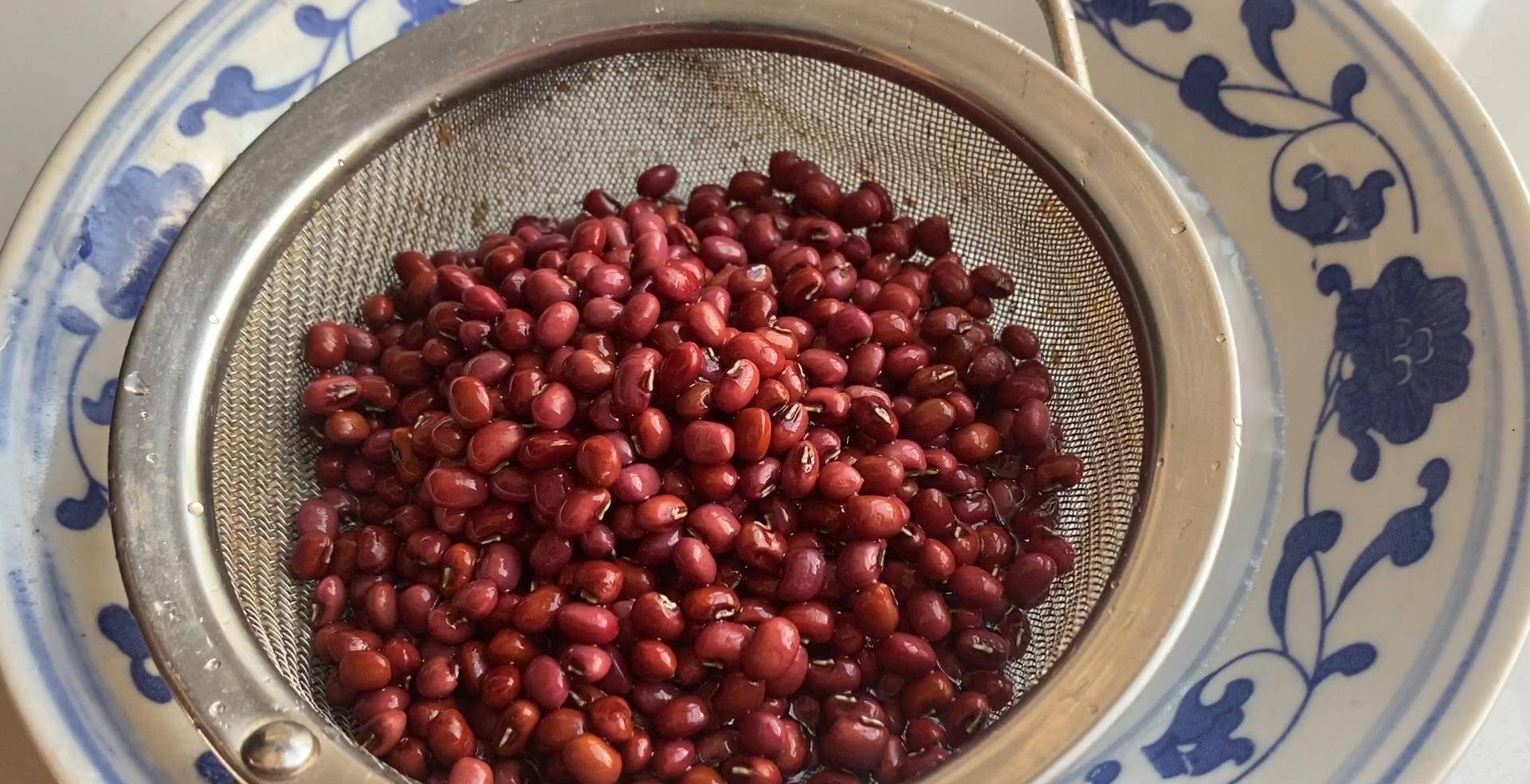 泡好的红豆倒入滤网里,过滤出水分,吸收了水分的红豆,内部结构会软