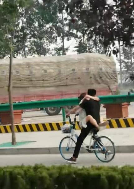 原创实拍:公路上偶遇"连体人",男女共骑一辆单车,网友直言太危险