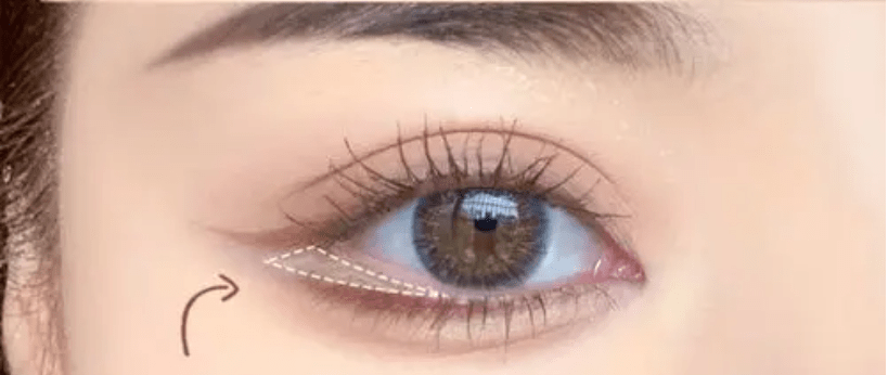 使用棕色眉笔或眼影色,在眼下位置加重卧蚕线,并使用化妆刷将卧蚕线