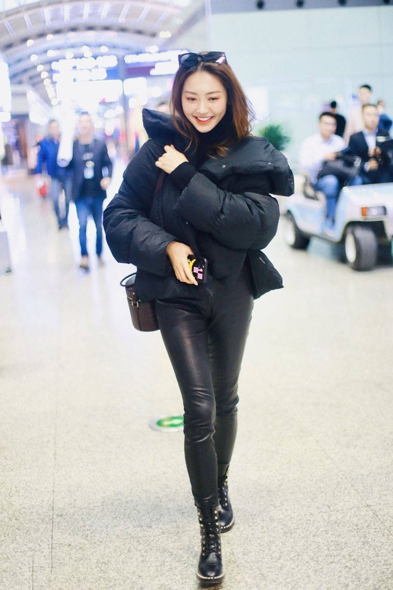 原创黄梦莹机场造型甜美可人黑色羽绒服紧身皮裤显瘦还时髦