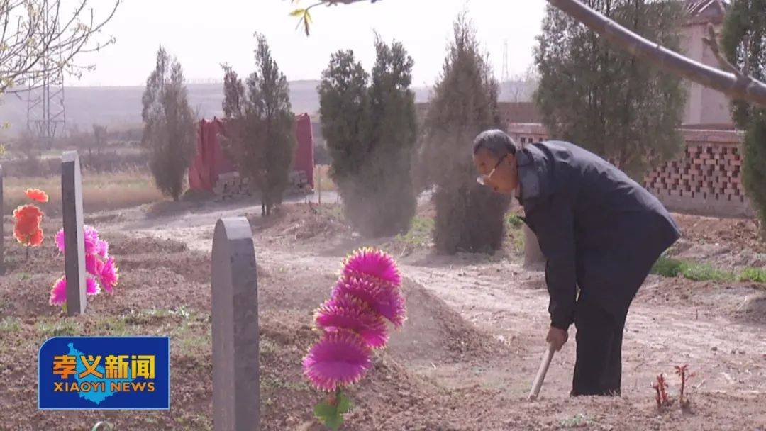 坟前,为逝者墓冢填土,擦拭灵位,在每个灵位前摆放一束绢花,四鞠躬行礼