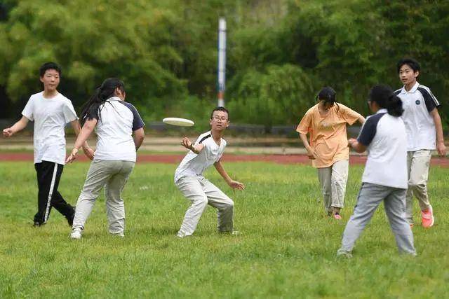 莫干山镇中心学校的学生在体育课上进行飞盘游戏.