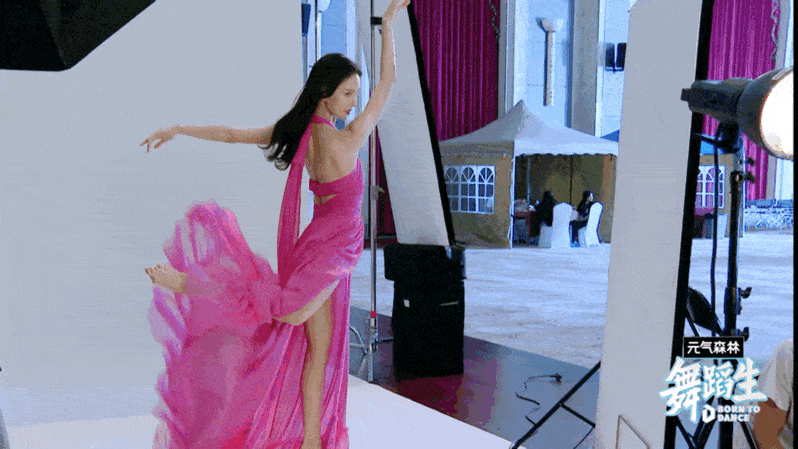 她身穿一袭粉色飘逸长裙,随风飘舞,动态起舞美感十足