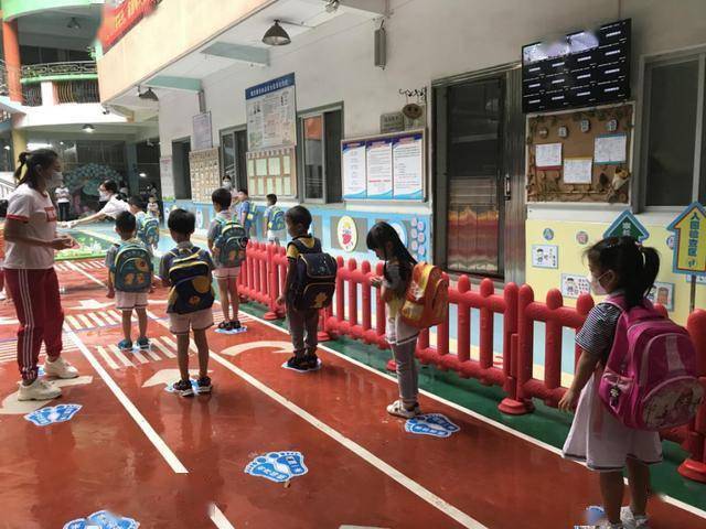 城中幼儿园小朋友在缓冲区有序入园.