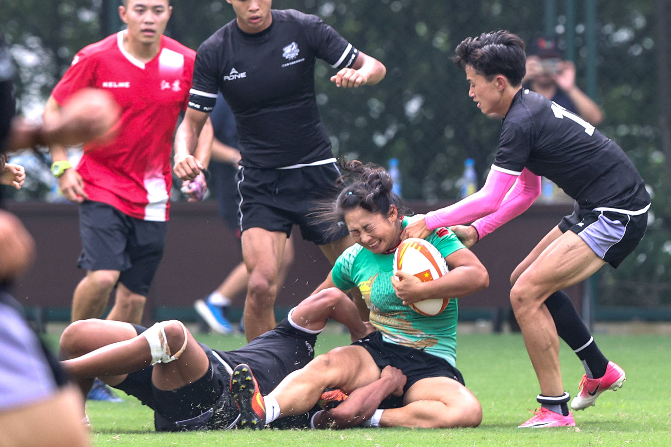 7月8日,中国女子橄榄球队球员于丽萍(右二)在比赛中拼抢.