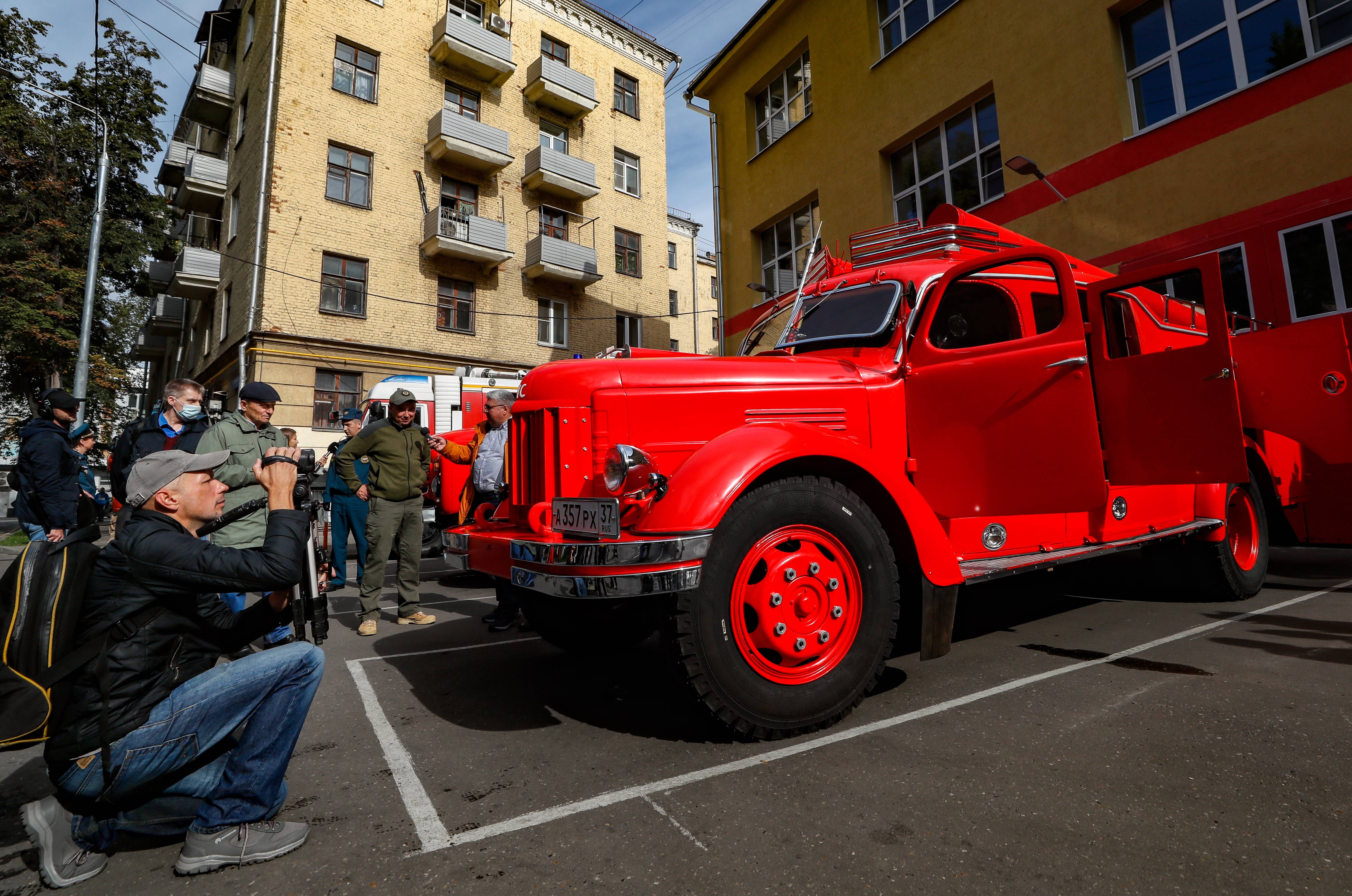 9月16日,在俄罗斯莫斯科,一名男子为一辆老式消防车参加拉力赛做准备.