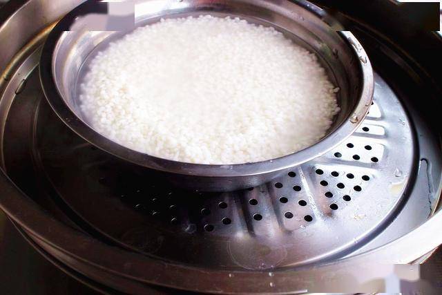 3,现在我们将糯米放到碗中,然后开水上锅蒸糯米,将糯米蒸熟即可.