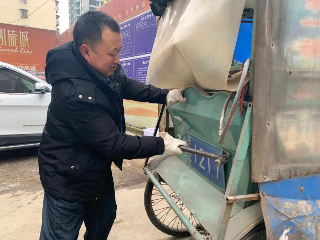 工作人员正在拆除人力客运三轮车的车牌