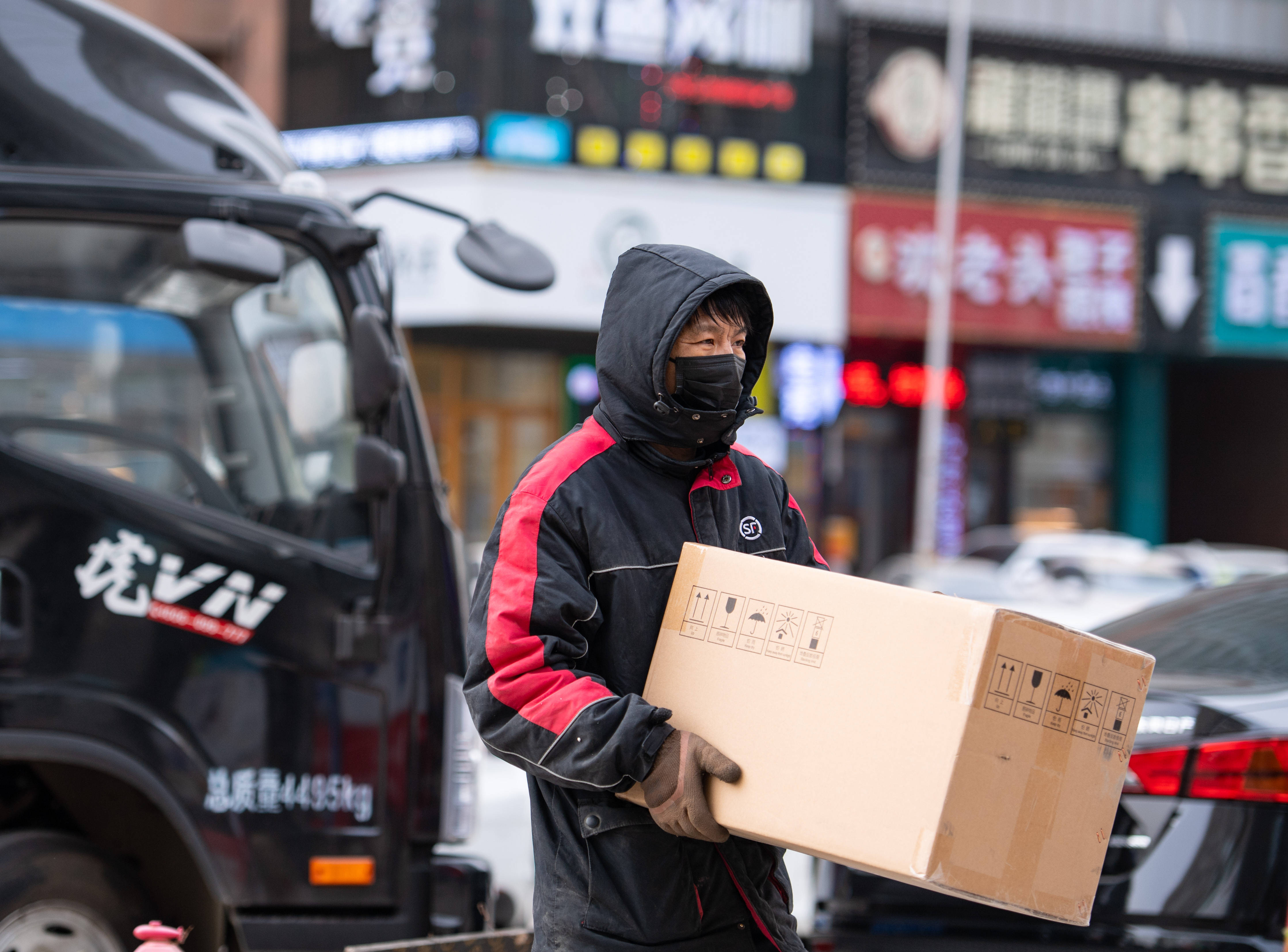 1月6日,在沈阳市浑南区浑南四路,一名快递员搬运货物.