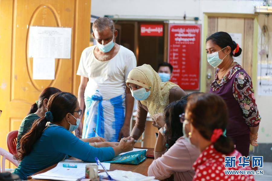 1月24日,缅甸仰光的一名社区管理办公室工作人员向居民发放新冠疫苗
