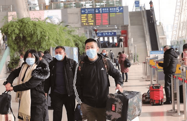 图为27日,在南京火车站进站口,旅客戴口罩有序进站.(段利雷 宋宁 摄)