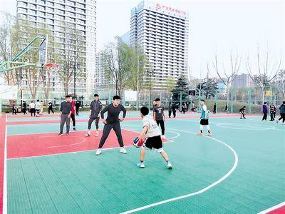 市民在石家庄体育公园笼式篮球场内运动.