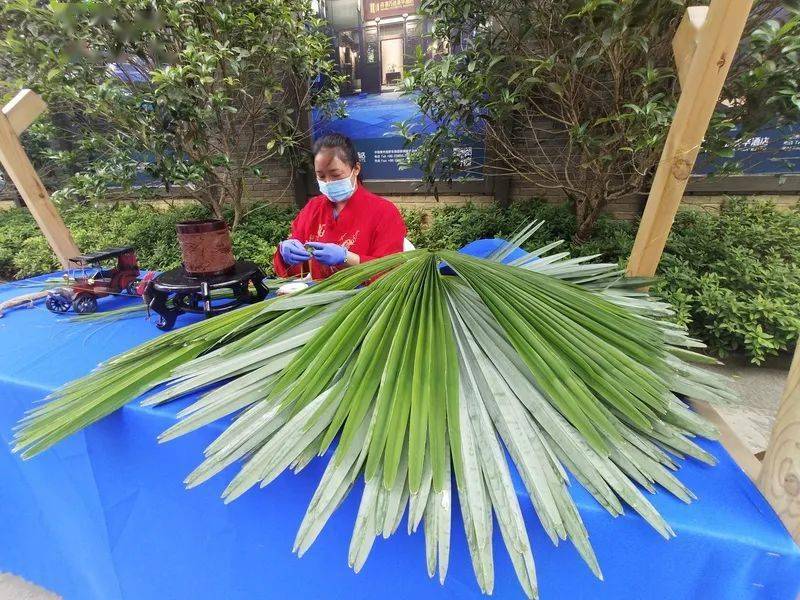 在第二届中国丹寨非遗周上,非遗传承人正在用棕叶编织手工艺品.