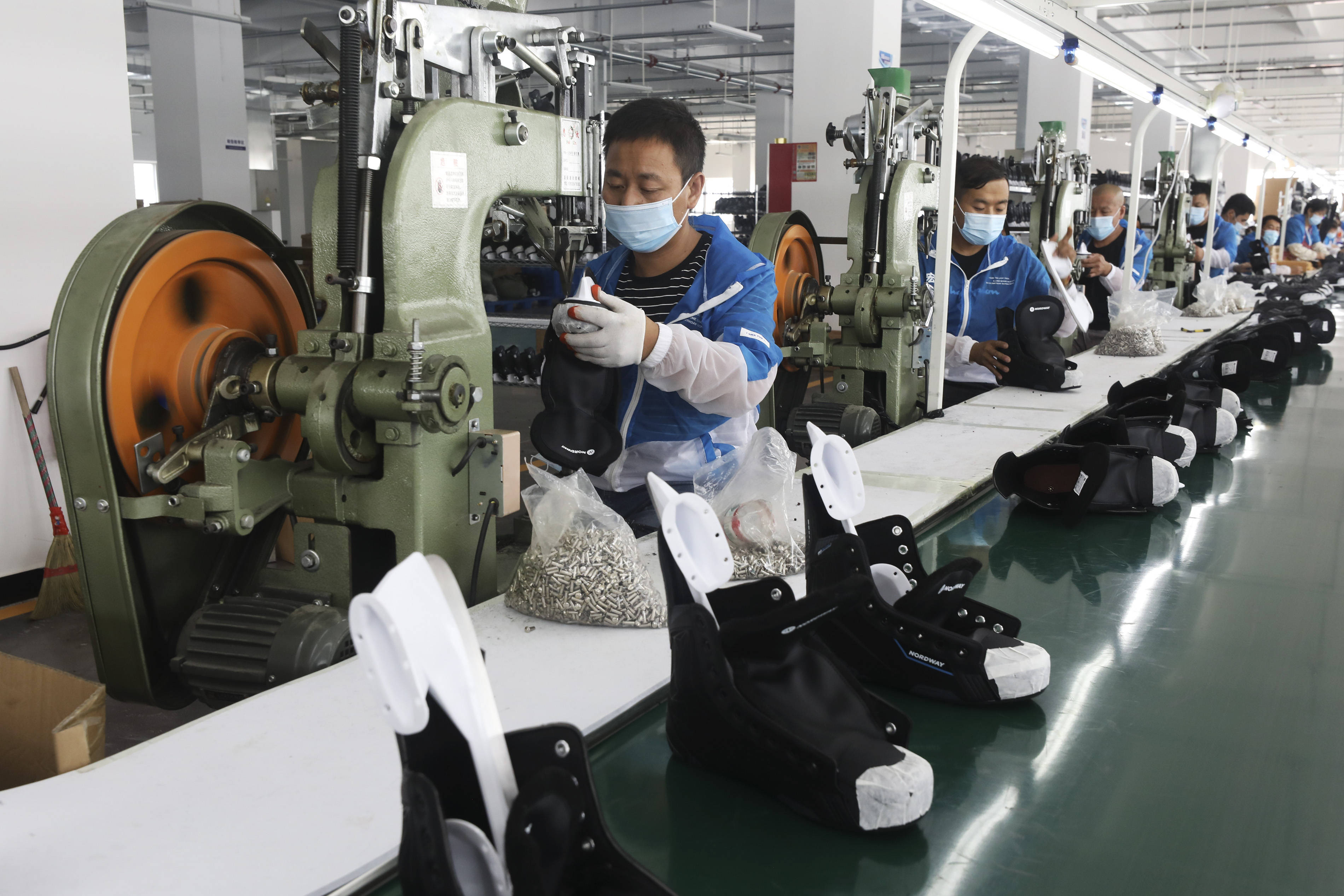 7月7日,在张家口高新区冰雪运动装备产业园,工人在一家冰球鞋生产企业