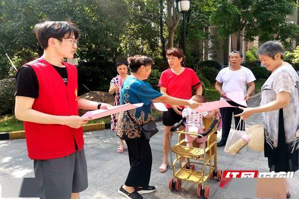 桂花坪街道工作人员在居民小区发放宣传资料.