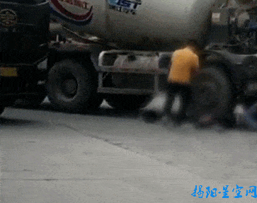 灯停在路中,一黑衣男子横躺在车轮旁,一辆女装摩托车躺倒在泥罐车前方