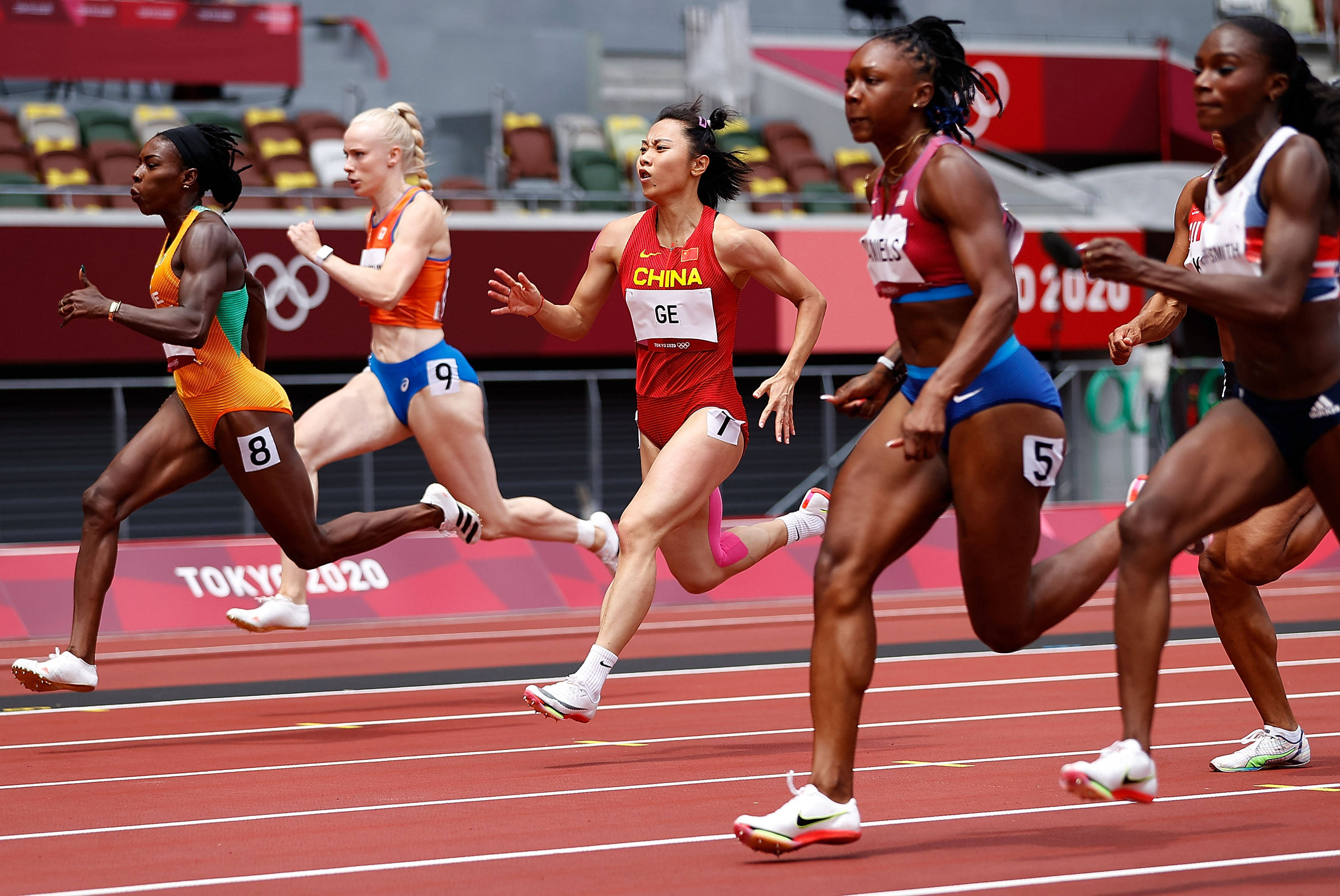 7月30日,中国选手葛曼棋(中)在田径女子100米预赛中.