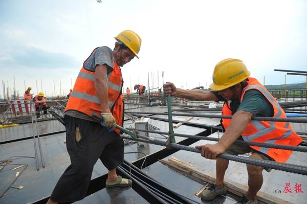 在南昌轨道交通产业园工地上,工人们头顶烈日搭建建筑物的钢筋结构.
