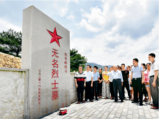 年逾九旬的钟宜龙老人在松毛岭战斗无名烈士墓前介绍松毛岭战役的历史