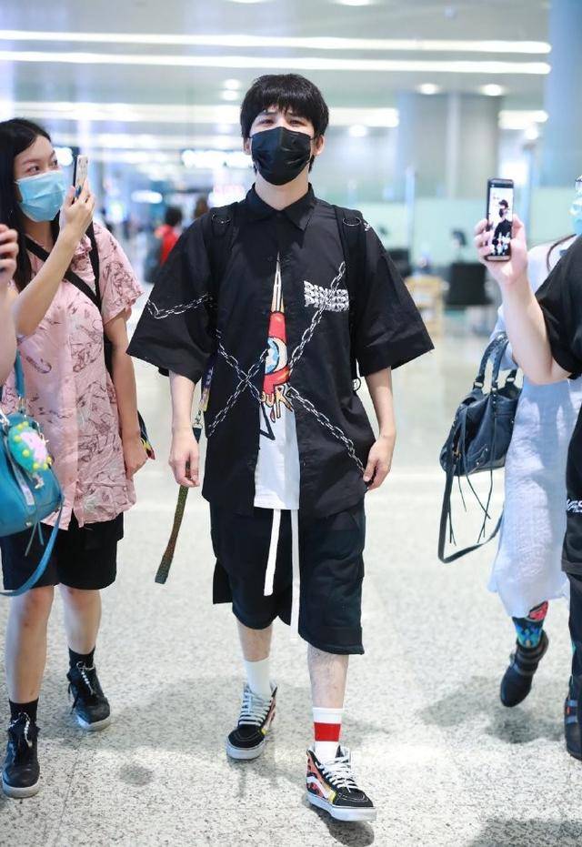 36岁大张伟低调走机场,穿印花t恤搭配锁链衬衫,顺毛发型有点乖