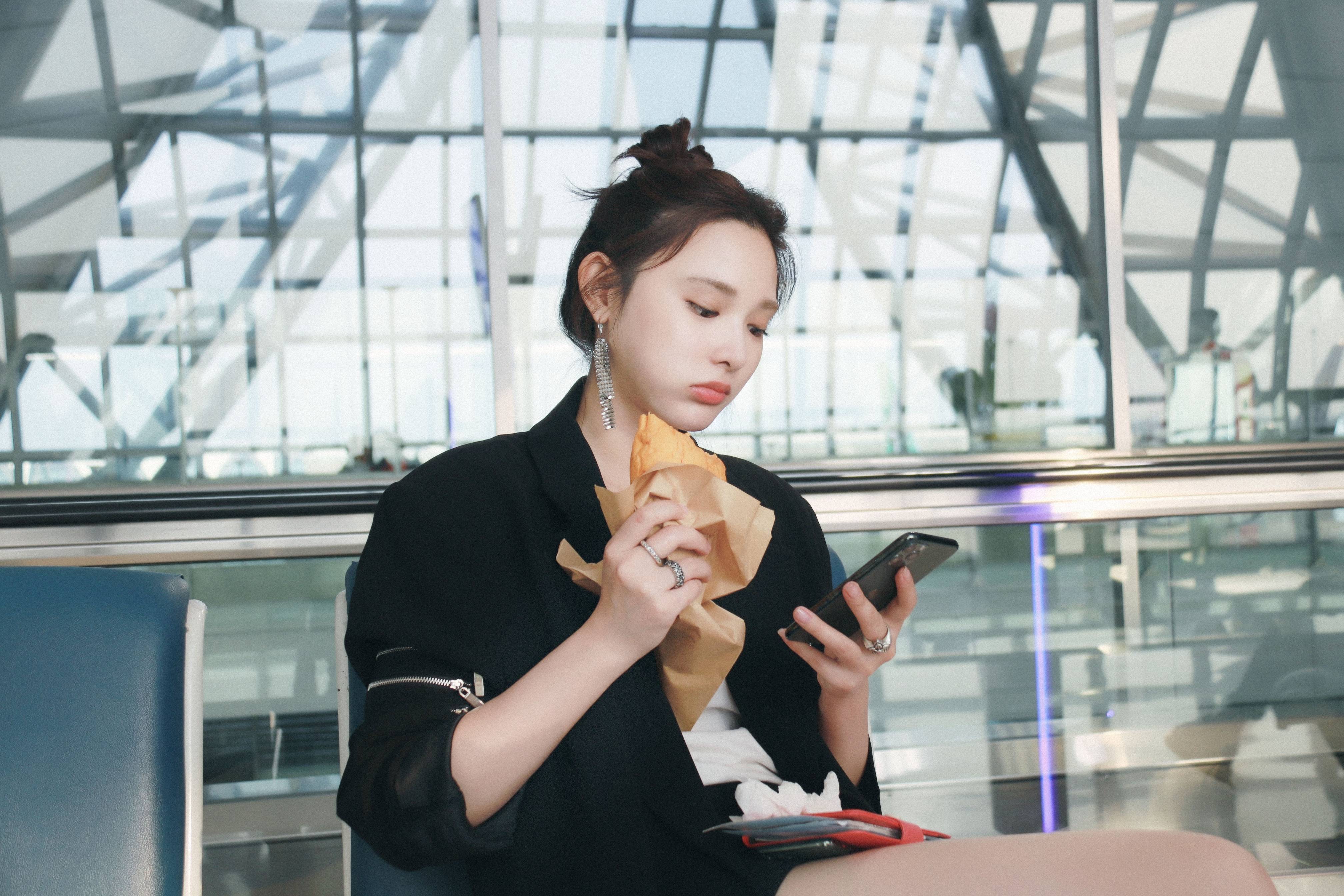 彭小苒机场吃牛角包,西装造型时髦吸睛,单边银色耳环甜美帅气