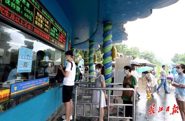 26日,东湖风景区售票处,游人自觉戴口罩站在一米间隔线有序排队购票.
