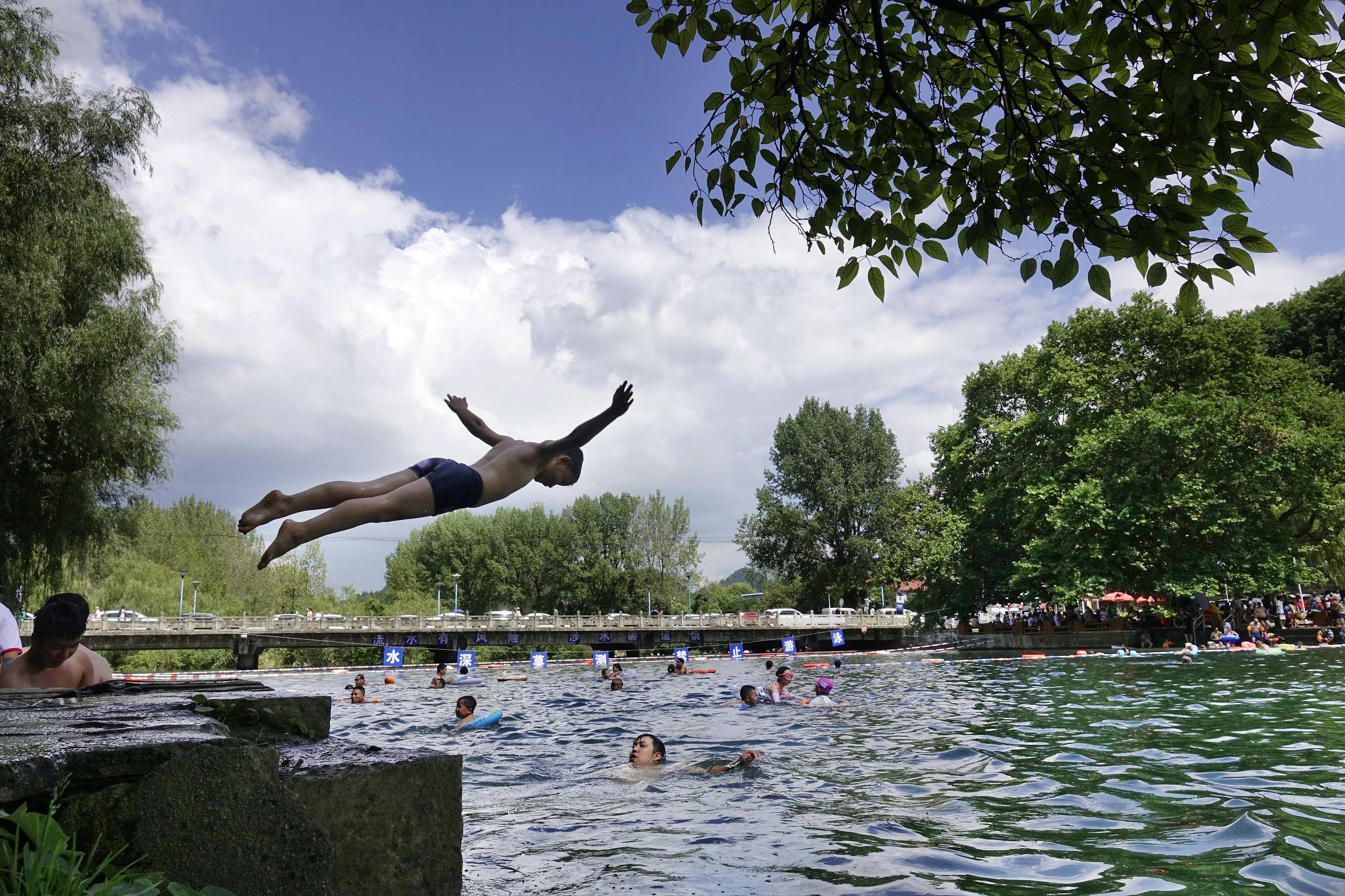 8月1日,贵阳,花溪河畔平桥段游人如织,人们在戏水避暑.