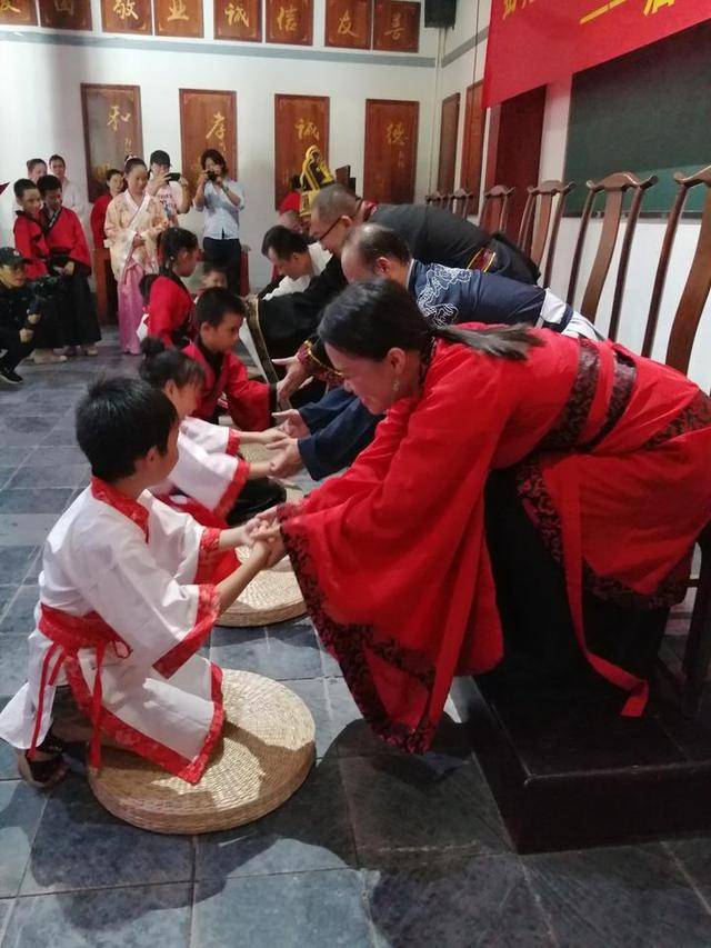 接着是"茶敬亲师",学童代表在老师前跪下,手上拿起茶杯向老师敬茶.