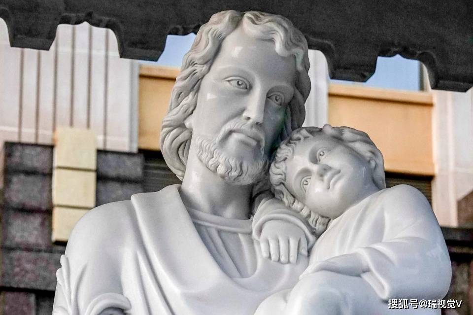 图为堂前广场北侧的圣若瑟纪念亭内的圣若瑟怀抱一名儿童的白色立式