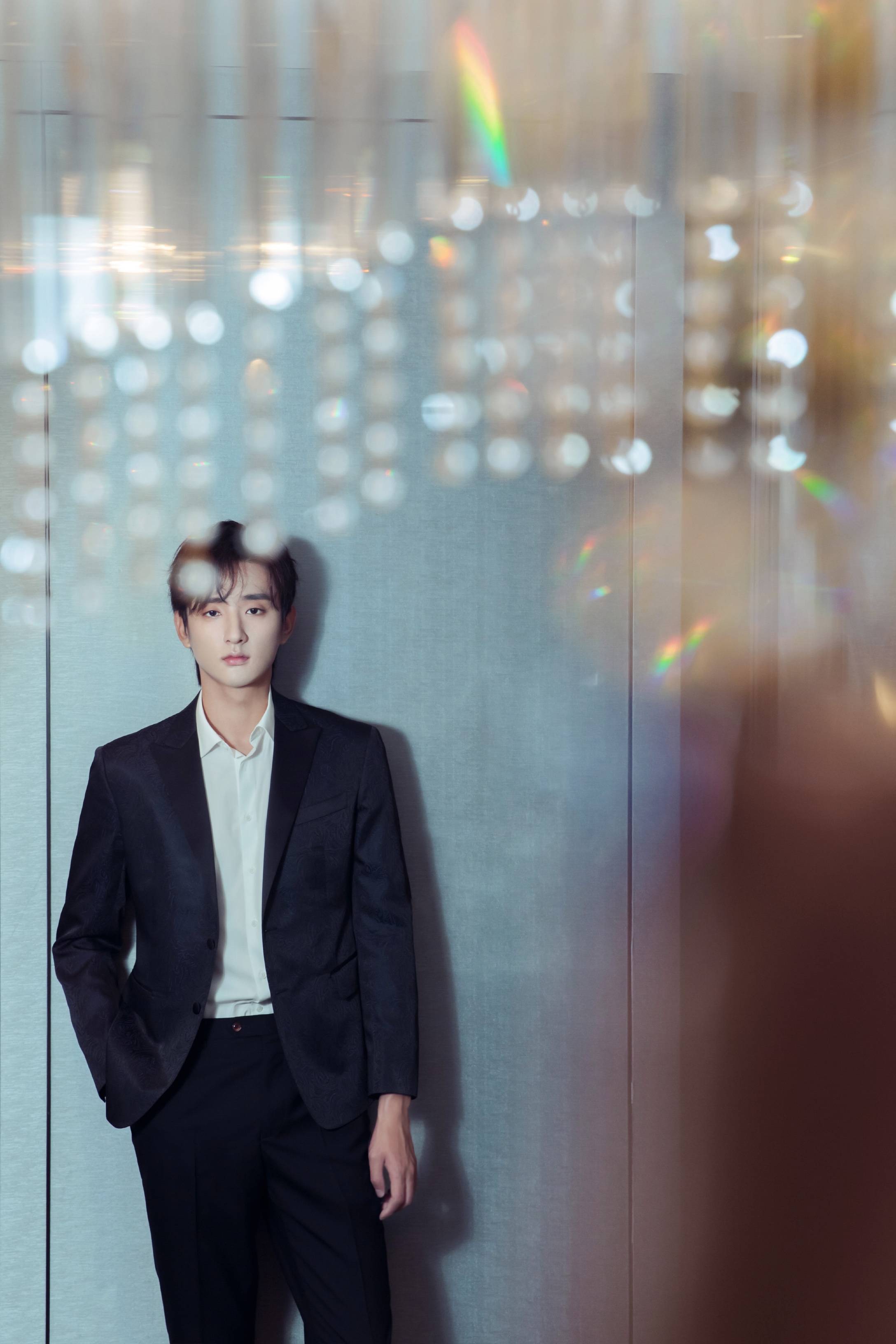 活动中,于小彤身着黑色刺绣西装站在熠熠灯光下,宛若"黑衣骑士"般温文