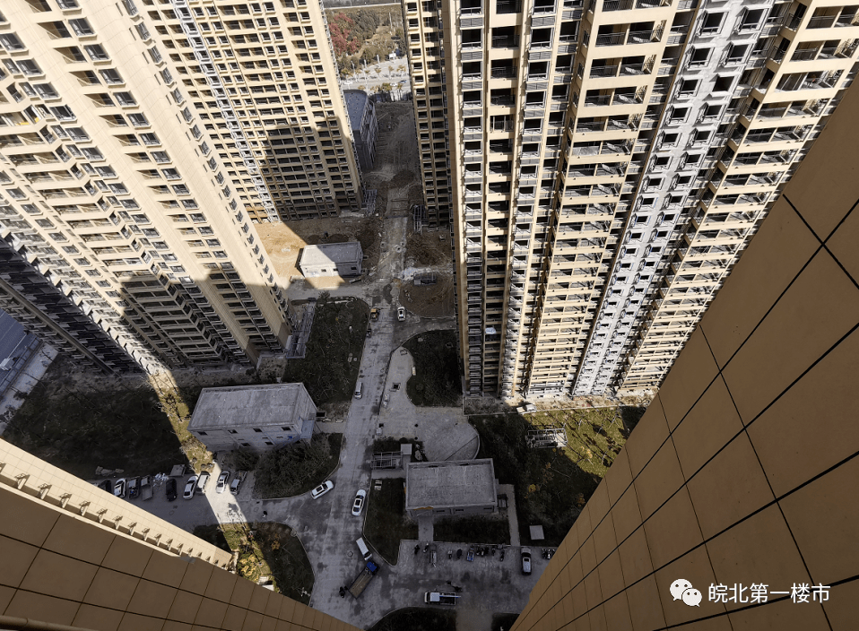 从高楼俯视向下看,可以看到小区路面还有一部分尚未完工,以及外墙面