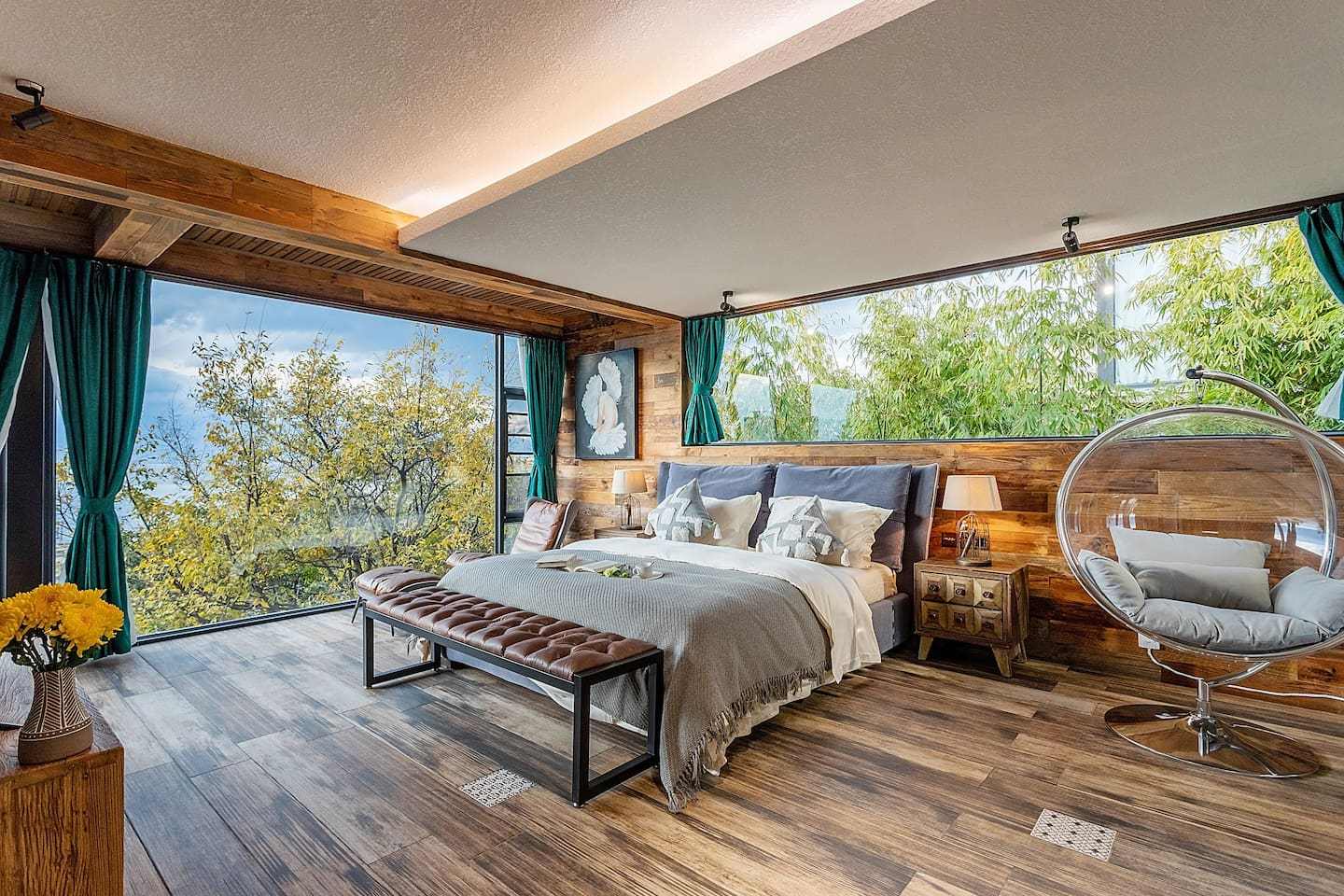 原创民宿房间是木头盒子设计,大床右侧有整面墙壁的玻璃落地窗