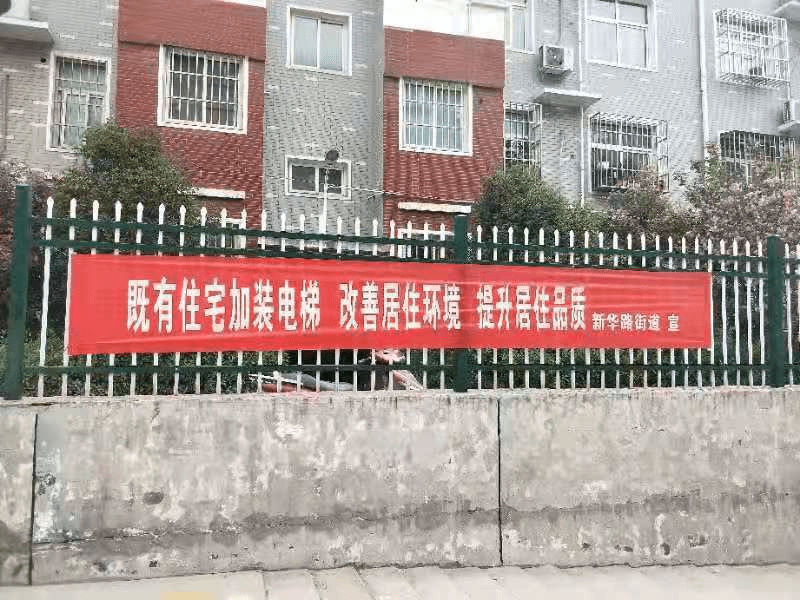 工作人员走进小区开展老旧小区改造和住宅增设电梯惠民政策的张贴宣传