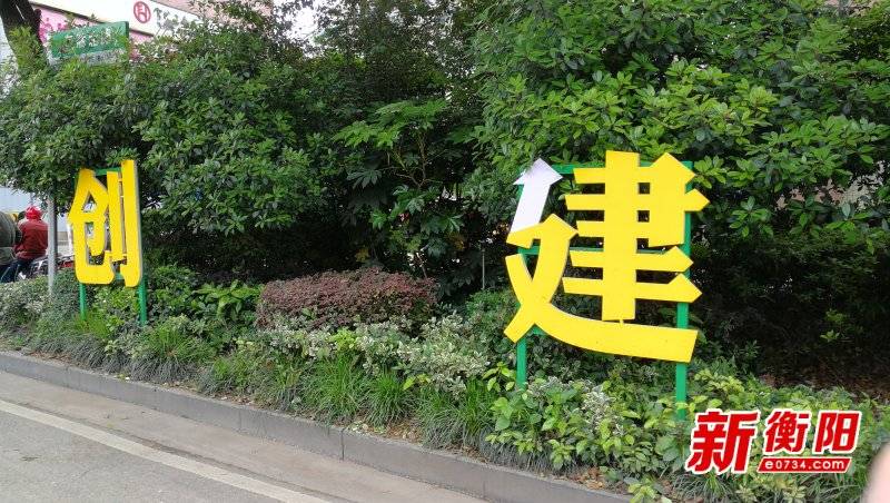 绿化带上,发现"创建文明城市"公益宣传广告中的"建"和"明"已遭人为