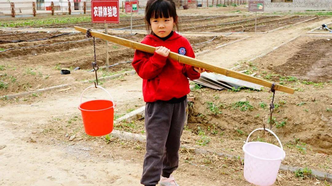 宝贝们在老师的讲解下了解了扁担挑水的技巧,争先恐后的拿起了扁担