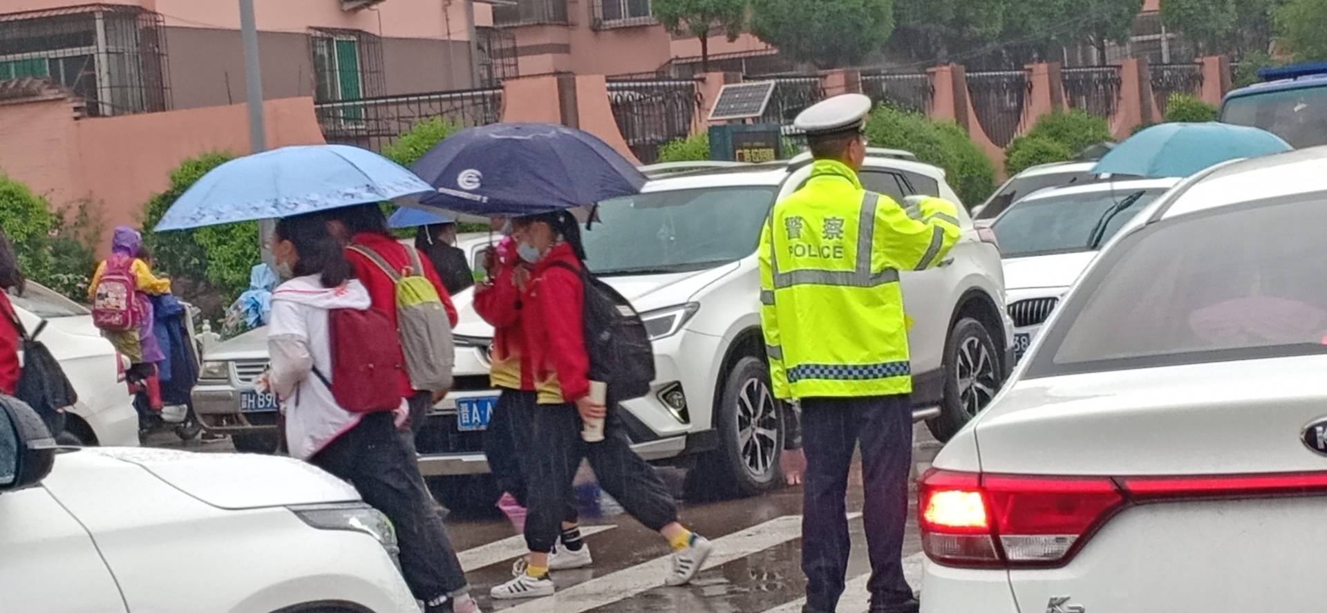 民警通过指挥手势对过往车辆和行人进行安全疏导