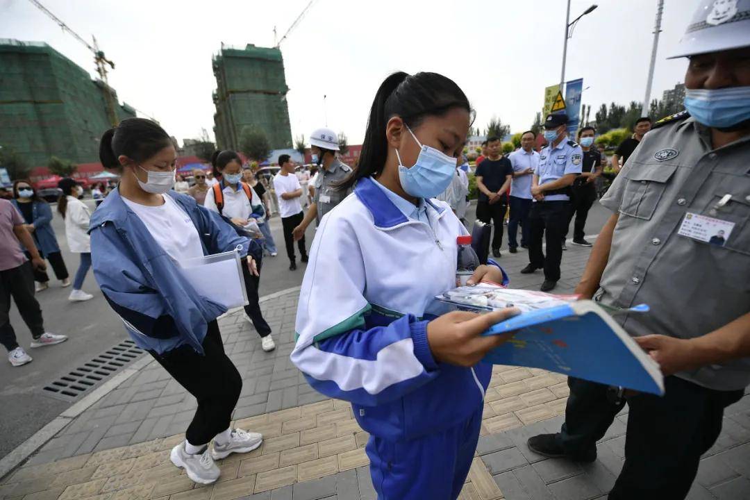 经过测温通道,正式进入考点按顺序走进学校大门考生们戴着口罩在老师