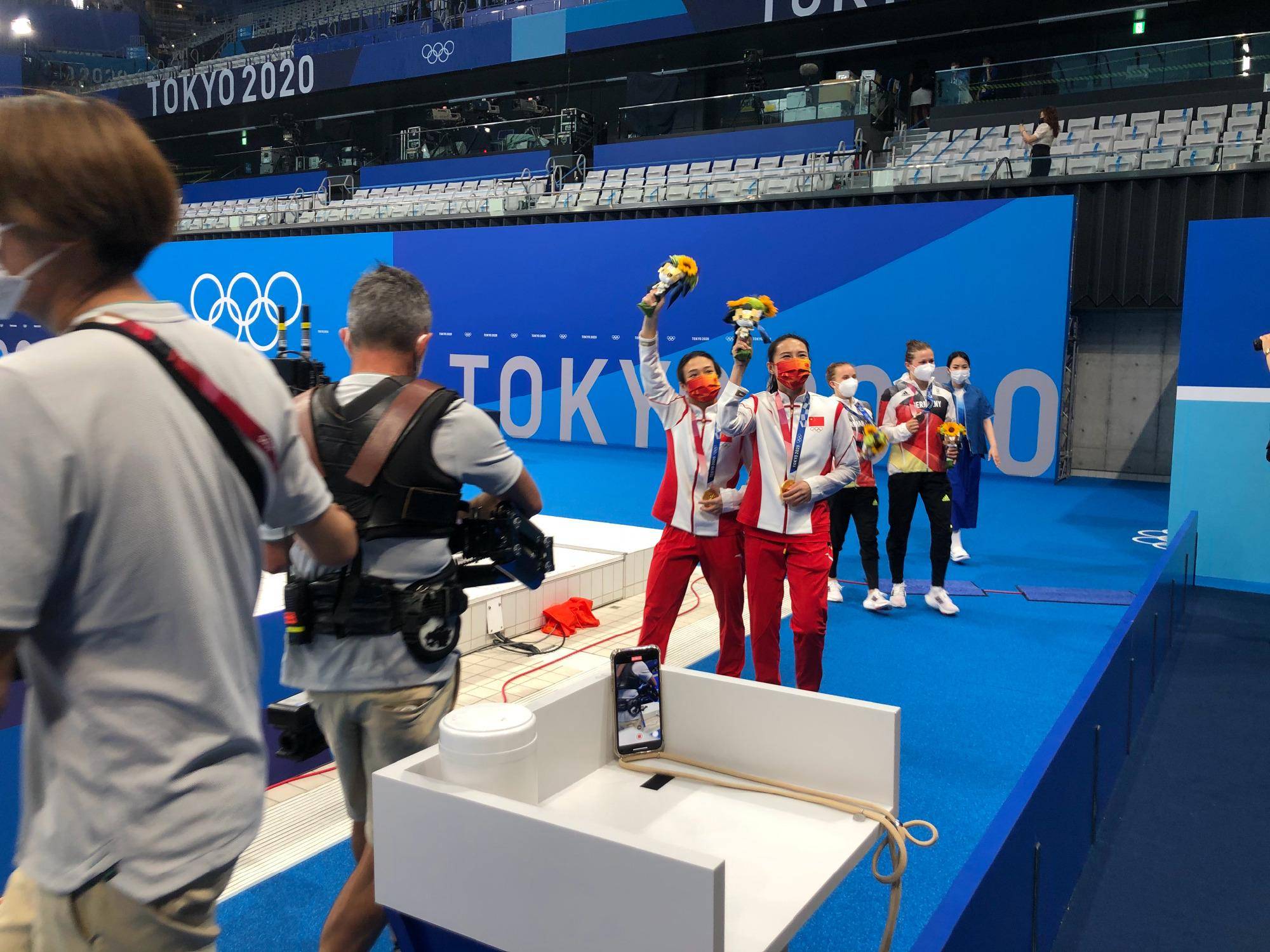 郭晶晶见证了中国队夺冠，身穿蓝色套装配中国红领带，连忙举手机拍照！