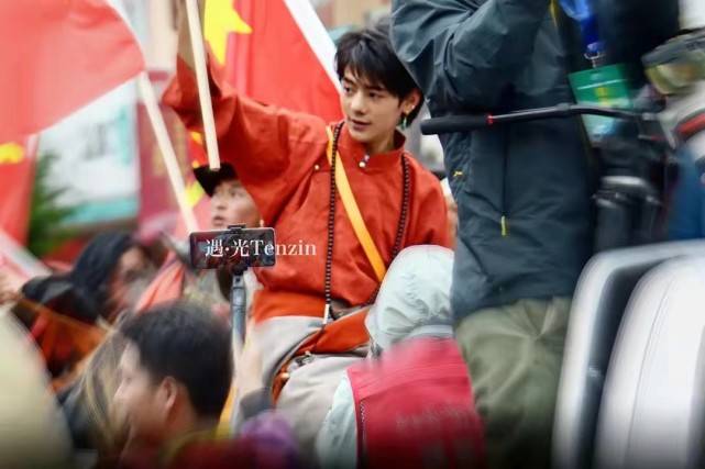 民族|丁真骑白马上街超有排面!穿藏袍举国旗意气风发,笑容好有感染力