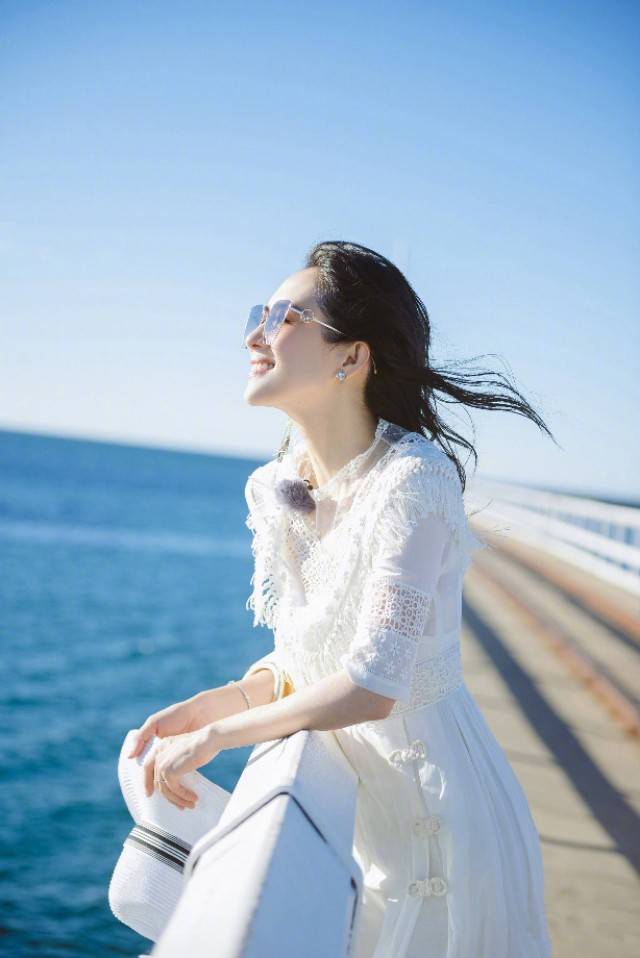 黑色|章子怡穿白色服装真好看，海边照相披印花丝巾，回眸一笑美艳动人