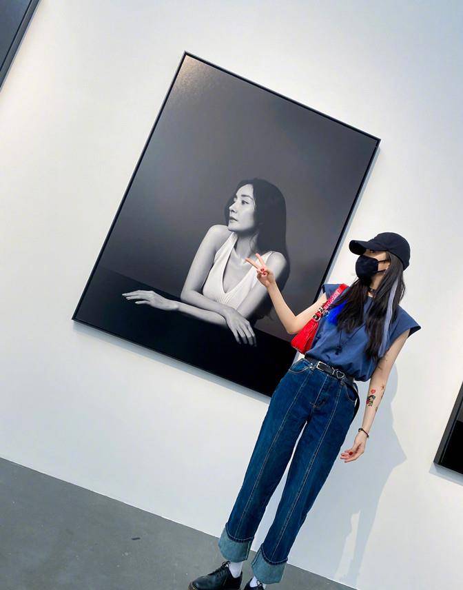 展真|杨幂遛弯看展真悠闲，穿无袖反手大花臂抢镜，见自己海报俏皮合拍